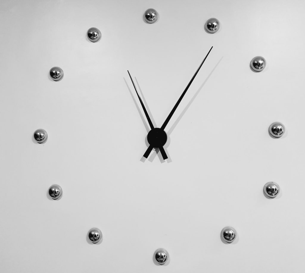 black and silver analog clock displaying 11:06 time